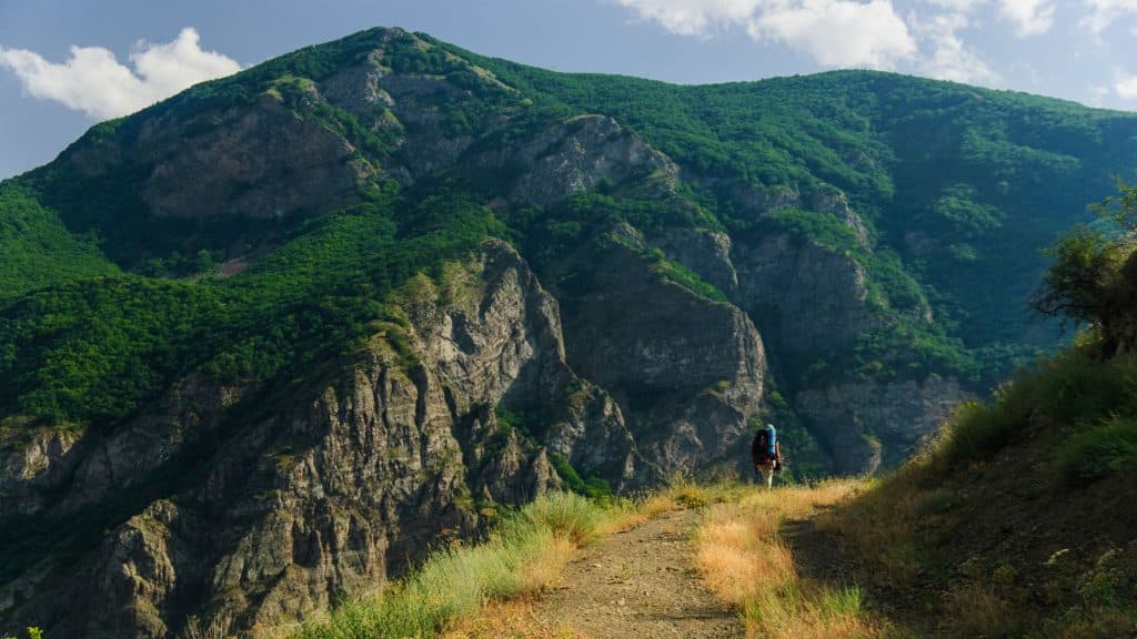 Backpacker hiking in Armenian mountains in Tatev monastery region. 