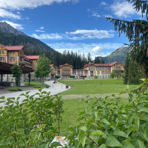 Dolomites Alta Via 1 with mountain range, building, and green lawn