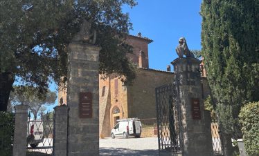 Montepulciano estate entrance with stone pillars, lion statues, and gates